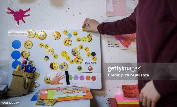 Aaron, who has early childhood autism, sticks a smiley on a whiteboard in his therapy room in Korb, Germany, 17 November 2017. These are super points...