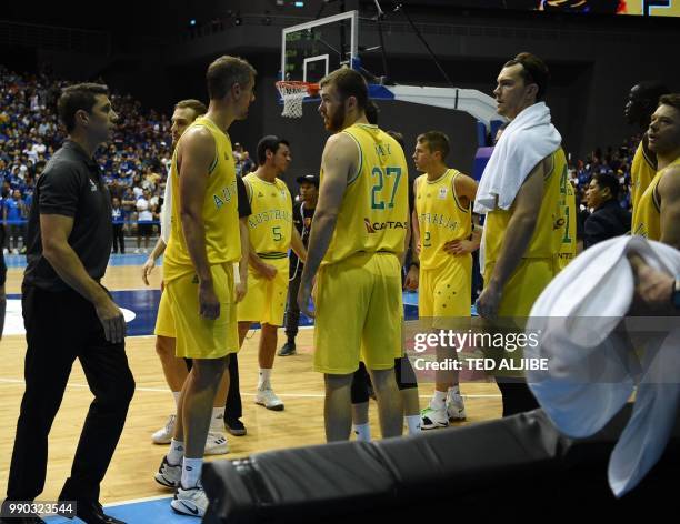 In this photo taken July 2 Australian players and officials gather at their bench after a brawl with Philippine players during their FIBA World Cup...