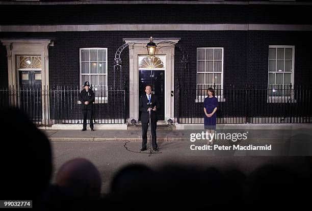 Prime Minister David Cameron speaks in front of Number 10 Downing Street watched by his wife Samantha on May 11, 2010 in London, England. After five...