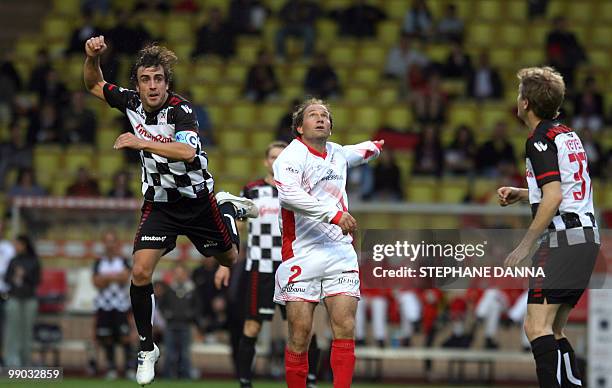 Spanish driver Fernando Alonso vies with Peter Rungalddier during a charity football match between Prince Albert's Star Team and the F1 "Nazionale...