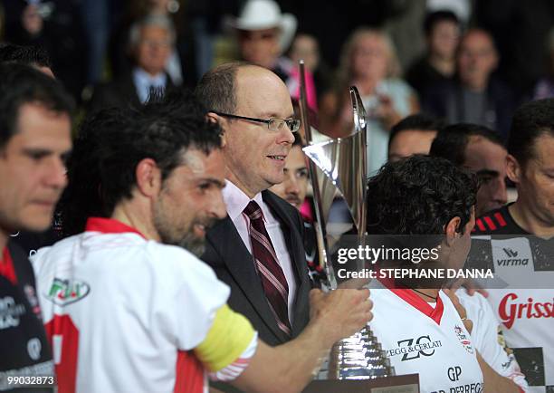 Prince Albert II of Monaco is pictured as he gives the trophy at the end of a charity football match between Prince Albert's Star Team and the F1...