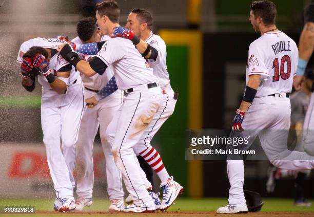 The Miami Marlins celebrate the walk off single by Yadiel Rivera in the tenth inning against the Tampa Bay Rays at Marlins Park on July 2, 2018 in...