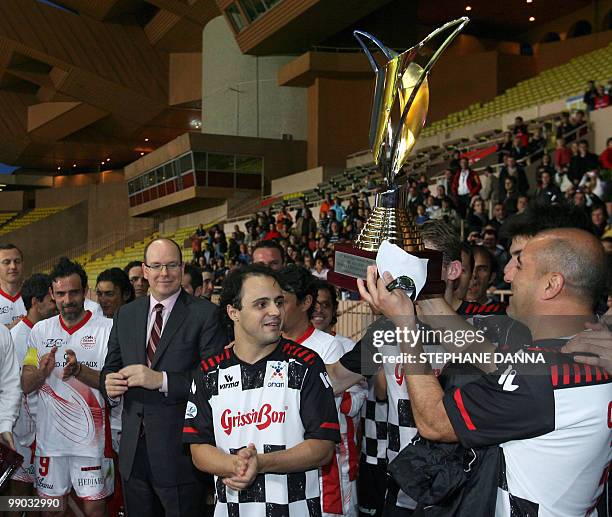 Nazionale Piloti" drivers's team players celebrate after receiving the trophy from Prince Albert II of Monaco at the end of a charity football match...