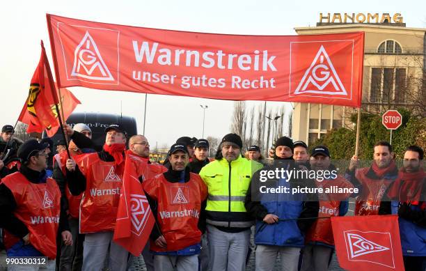 Members of the IG Metall strike in front of the Komatsu company and carry banners reading 'Warnstreik' in Hanover, Germany, 09 January 2018. The...