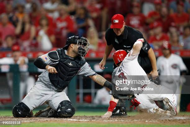 Scooter Gennett of the Cincinnati Reds slides at home plate ahead of the tag by Omar Narvaez of the Chicago White Sox to score a run in the eighth...