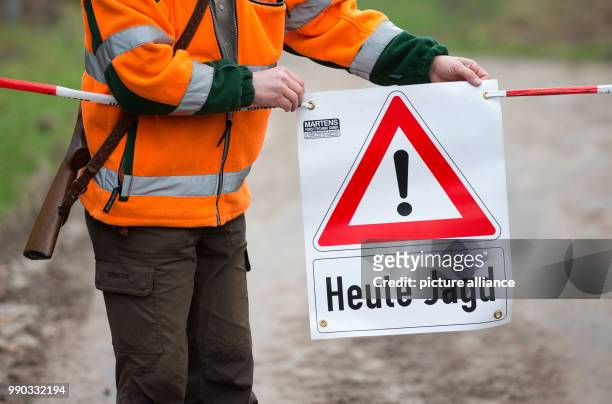 Hunter sets up a sign that reads 'Heute Jagd' during a driven hunt across a forest near the motorway A2 in Bielefeld, Germany, 09 January 2018. Some...