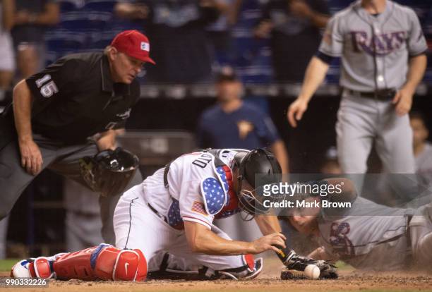 Realmuto of the Miami Marlins misses the tag at homeplate on Daniel Robertson of the Tampa Bay Rays in the ninth inning against the Tampa Bay Rays at...