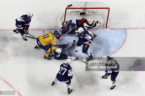 Carl Gunnarsson of Sweden scores his team's first goal against goalkeeper Eddy Ferhi of France during the IIHF World Championship group C match...