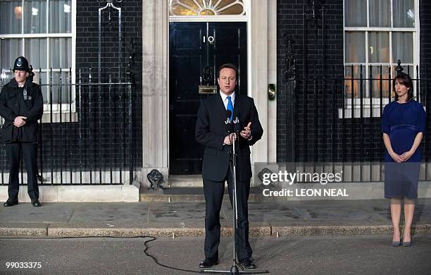 Britain's new Prime Minister, Conservative party Leader David Cameron, watched by his wife Samantha, addresses the media outside 10 Downing Street in...