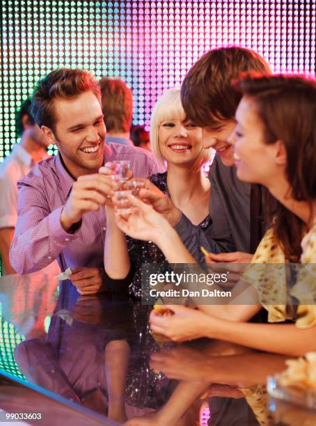 young people drinking tequila shots in a nightclub - tequila drink stock pictures, royalty-free photos & images