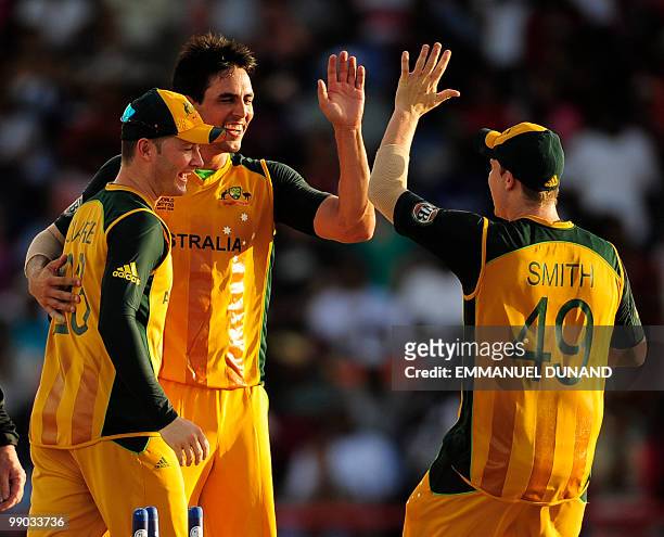 Australian bowler Mitchell Johnson celebrates with captain Michael Clarke and Steven Smith after taking the wicket of West Indies batsman Dwayne...