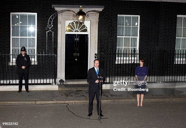 David Cameron, the new U.K. Prime minister, center, addresses the media as his wife Samantha looks on, right, outside 10 Downing Street in London,...