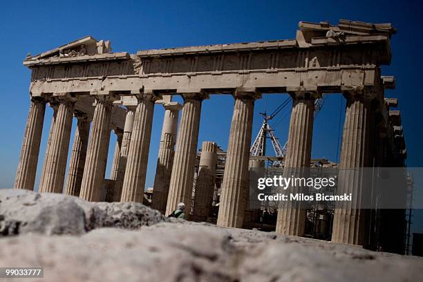 Tourist stands in front of the Parthenon Temple on the ancient Acropolis hill, one of the city's modern landmarks on May 11, 2010 in central Athens....