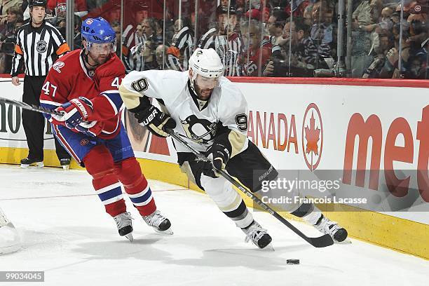 Pascal Dupuis of the Pittsburgh Penguins skates with the puck in front of Marc-Andre Bergeron of Montreal Canadiens in Game Four of the Eastern...