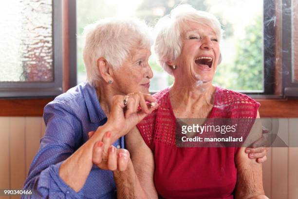 two senior girlfriends 83 years old smoke marijuana together - smoking issues stock pictures, royalty-free photos & images