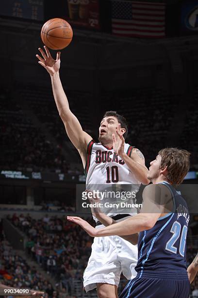 Carlos Delfino of the Milwaukee Bucks puts the ball up against Kyle Korver of the Utah Jazz on March 12, 2010 at the Bradley Center in Milwaukee,...