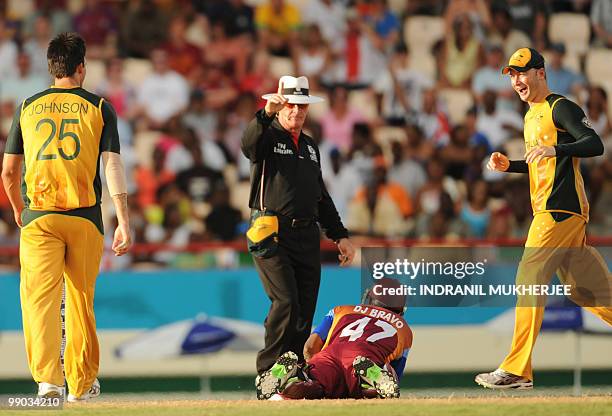 Australian cricketers Mitchell Johnson and Michael Clarkereact as Umpire Rudi Koertzen of South Africa signals the run-out of West Indies cricketer...