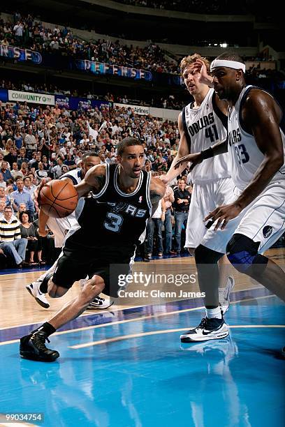 George Hill of the San Antonio Spurs drives to the basket past Brendan Haywood and Dirk Nowitzki of the Dallas Mavericks in Game Five of the Western...