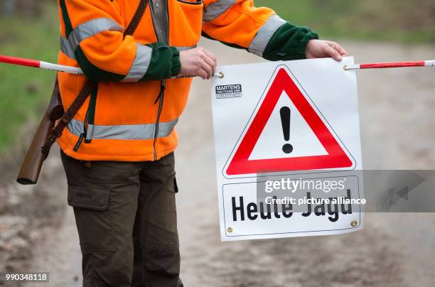 Hunter sets up a sign that reads 'Heute Jagd' during a driven hunt across a forest near the motorway A2 in Bielefeld, Germany, 09 January 2018. In...