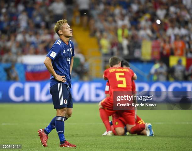 Keisuke Honda of Japan looks dejected beside Belgium players after Japan's 3-2 loss in the World Cup round of 16 in Rostov-On-Don, Russia, on July 2,...