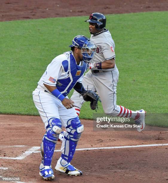 Cleveland Indians' Rajai Davis scores behind Kansas City Royals catcher Salvador Perez on a sacrifice fly by Michael Brantley in the third inning...