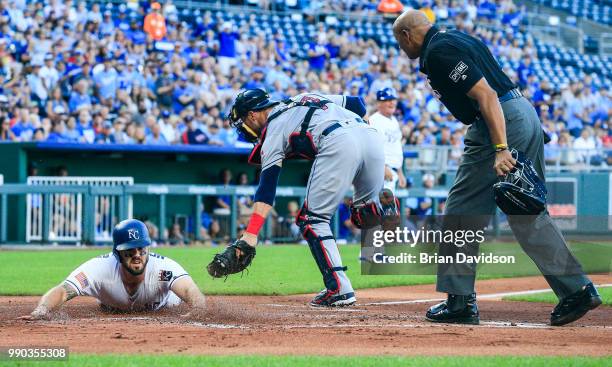 Mike Moustakas of the Kansas City Royals slides into home under the tag of Yan Gomes of the Cleveland Indians for a run during the first inning at...