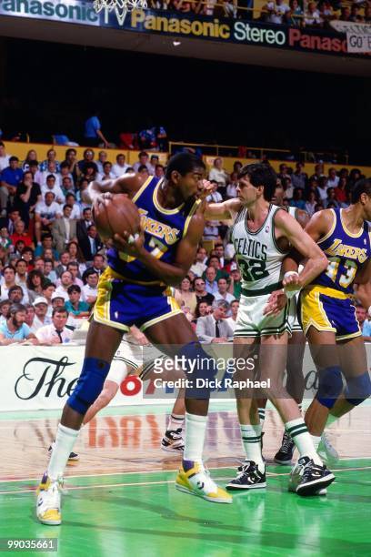 Magic Johnson of the Los Angeles Lakers rebounds against Kevin McHale of the Boston Celtics during the 1987 NBA Finals at the Boston Garden in...