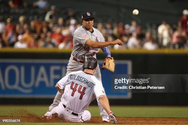 Infielder Yairo Munoz of the St. Louis Cardinals throws over the sliding Paul Goldschmidt of the Arizona Diamondbacks to complete a double play...