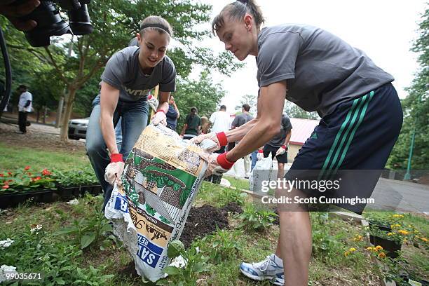 Shalee Lehning and Coco Miller of the Atlanta Dream help plant flowers at Collier Heights Park on May 11, 2010 in Atlanta, Georgia. NOTE TO USER:...