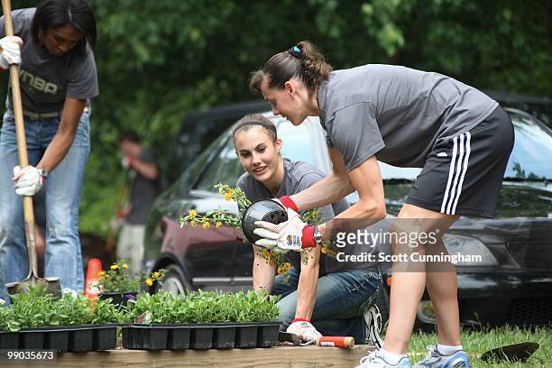 Shalee Lehning and Kelly Miller of the Atlanta Dream help plant flowers at Collier Heights Park on May 11, 2010 in Atlanta, Georgia. NOTE TO USER:...