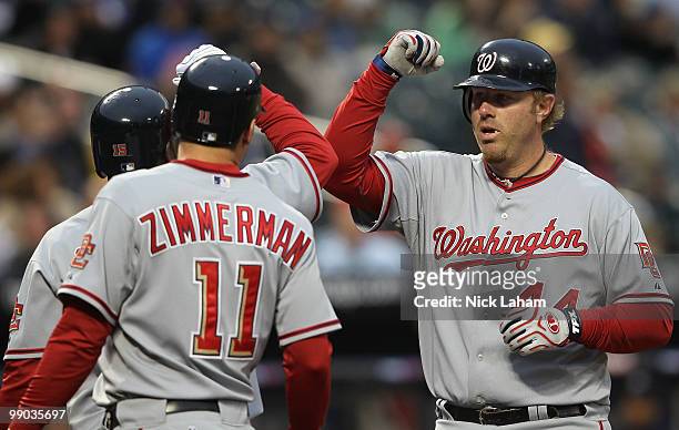 Adam Dunn of the Washington Nationals celebrates his three RBI homerun with scoring teammates Ryan Zimmerman and Cristian Guzman against the New York...