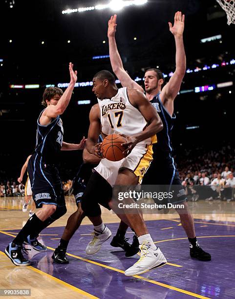 Andrew Bynum of the Los Angeles Lakers controls the ball between Kyle Korver and Kosta Koufos of the Utah Jazz during Game One of the Western...