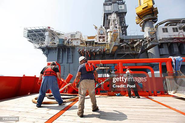 Sean Weichel Rodney Falgout and Kevin Reynolds, crew members aboard on the supply vessel Joe Griffin, connect hoses to transfer water and fuel to the...