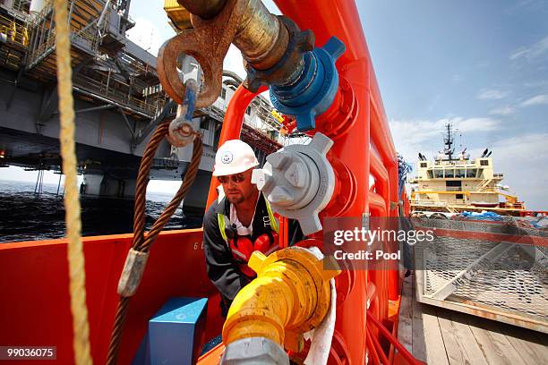 Scot Knapp, a crew member aboard on the supply vessel Joe Griffin, turns a valve to transfer fuel to the Development Driller III, background left,...