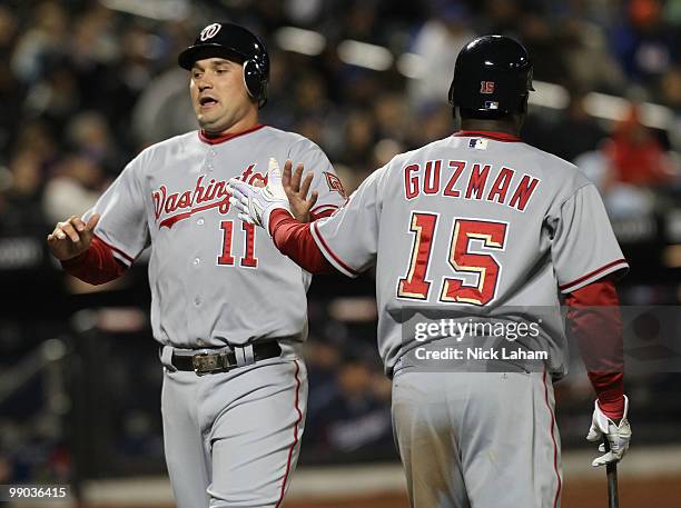 Ryan Zimmerman of the Washington Nationals celebrates scoring on a Ivan Rodriguez single with teammate Cristian Guzman against the New York Mets at...