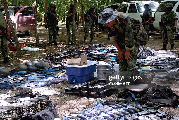 Ammo assault rifles and guns seized to alleged drug traffickers in a training camp are displayed in Higueras municipality, Nuevo Leon State, Mexico,...