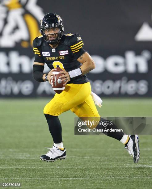 Jeremiah Masoli of the Hamilton Tiger-Cats rolls out for a pass against the Winnipeg Blue Bombers in a CFL game at Tim Hortons Field on June 29, 2018...