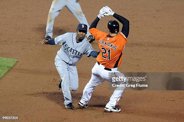 Chone Figgins of the Seattle Mariners tags out Nick Markakis of the Baltimore Orioles to start a double play at Camden Yards on May 11, 2010 in...