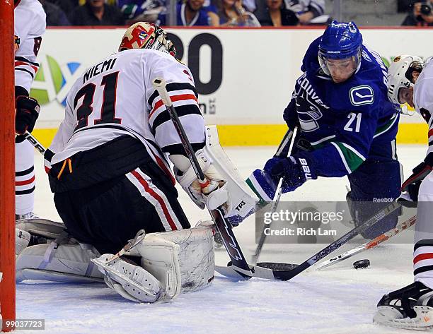 Mason Raymond of the Vancouver Canucks loses control of the puck while in close to goalie Antti Niemi of the Chicago Blackhawks during the first...