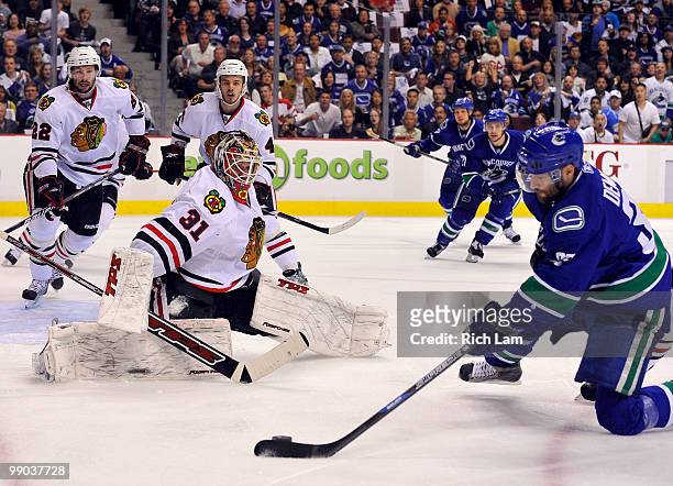 Pavol Demitra of the Vancouver Canucks tries to get a shot on goalie Antti Niemi of the Chicago Blackhawks while Troy Brouwer and Niklas Hjalmarsson...