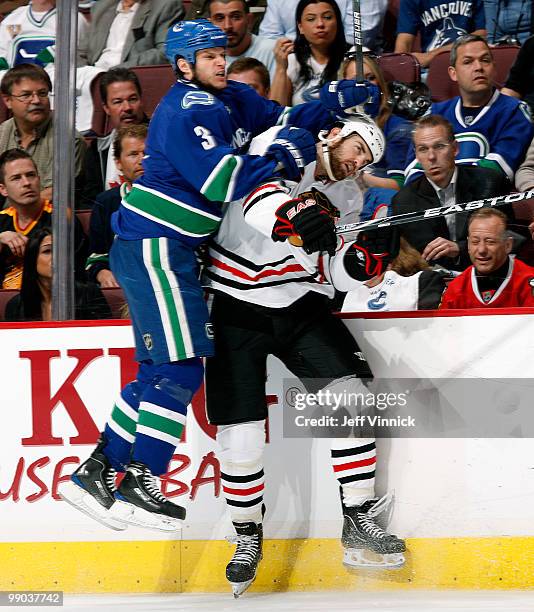 Kevin Bieksa of the Vancouver Canucks checks Andrew Ladd of the Chicago Blackhawks during first period action in Game 6 of the Western Conference...