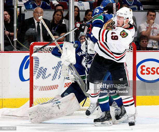Jonathan Toews of the Chicago Blackhawks deflects the puck off of goalie Roberto Luongo of the Vancouver Canucks in Game 6 of the Western Conference...