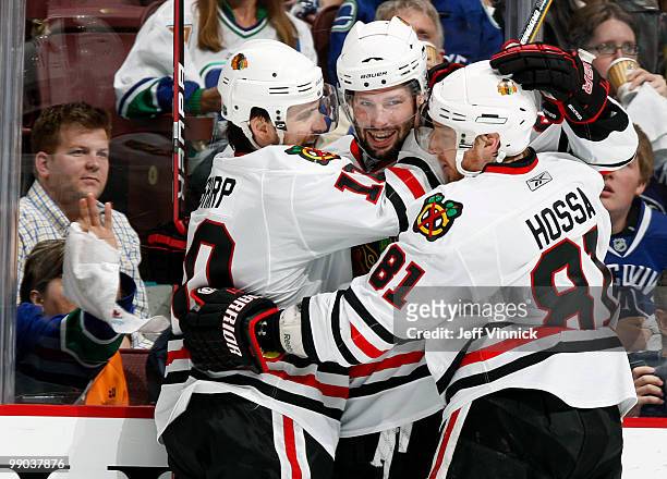 Patrick Sharp and Marian Hossa help teammate Troy Brouwer of the Chicago Blackhawks celebrate his goal in Game 6 of the Western Conference Semifinals...