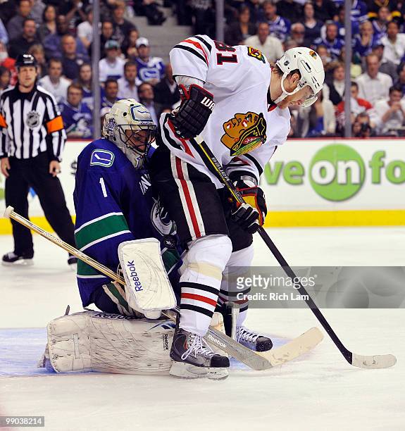 Goalie Roberto Luongo of the Vancouver Canucks makes a save with Marian Hossa of the Chicago Blackhawks in close during the second period in Game Six...