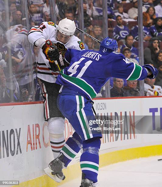 Andrew Alberts of the Vancouver Canucks hits Marian Hossa of the Chicago Blackhawks along the end boards during the second period in Game Six of the...