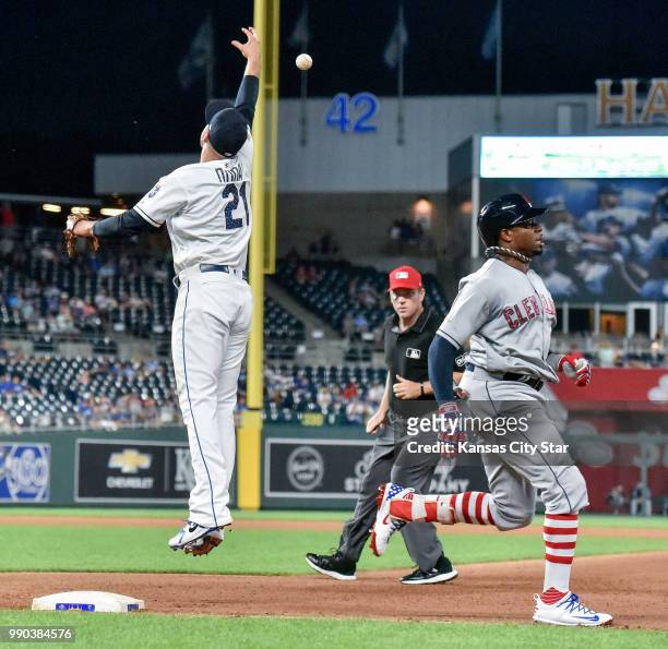 Cleveland Indians' Rajai Davis reaches first as the flip from Kansas City Royals relief pitcher Brian Flynn to first baseman Lucas Duda goes high in...