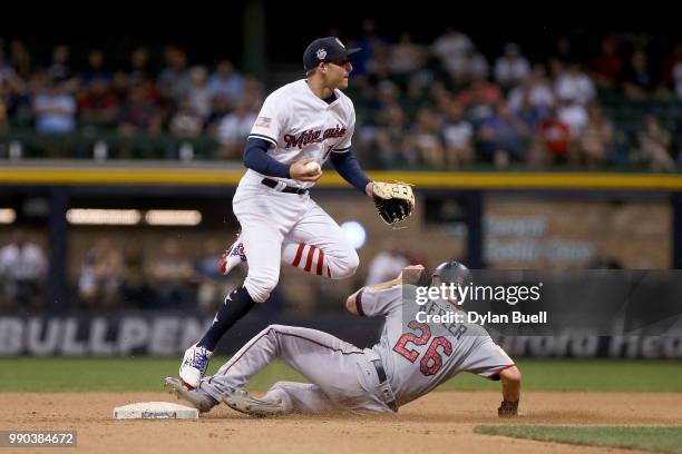 Brad Miller of the Milwaukee Brewers attempts to turn a double play past Max Kepler of the Minnesota Twins in the ninth inning at Miller Park on July...