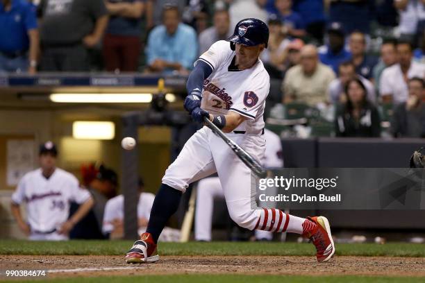 Travis Shaw of the Milwaukee Brewers hits a sacrifice fly in the ninth inning against the Minnesota Twins at Miller Park on July 2, 2018 in...