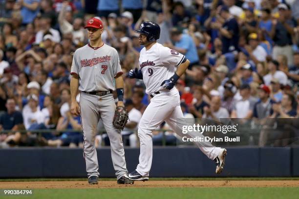 Manny Pina of the Milwaukee Brewers rounds the bases past Joe Mauer of the Minnesota Twins after hitting a home run in the fifth inning at Miller...