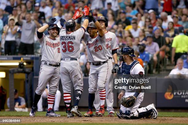 Robbie Grossman of the Minnesota Twins celebrates with Brian Dozier, Eddie Rosario, and Kyle Gibson after hitting a grand slam in the fifth inning...